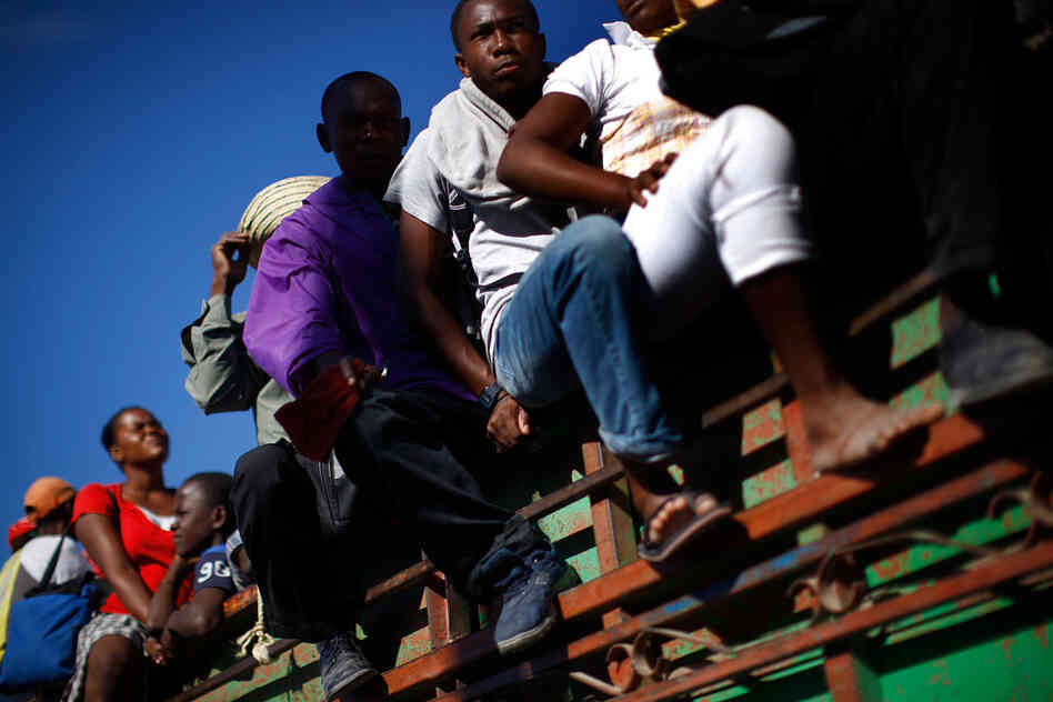 Haitians leave Port-au-Prince on a flatbed truck. Other towns in Haiti were also hit hard, but not much aid has made it beyond the devastated capital.