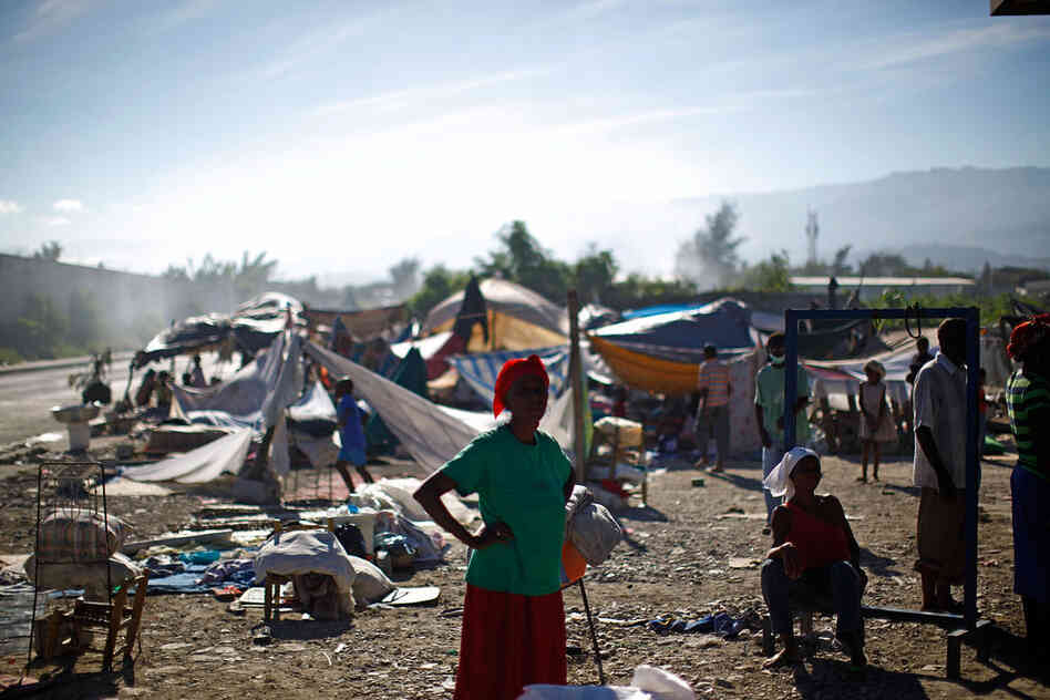 Refugees wait in a makeshift camp Saturday near downtown Port-au-Prince.