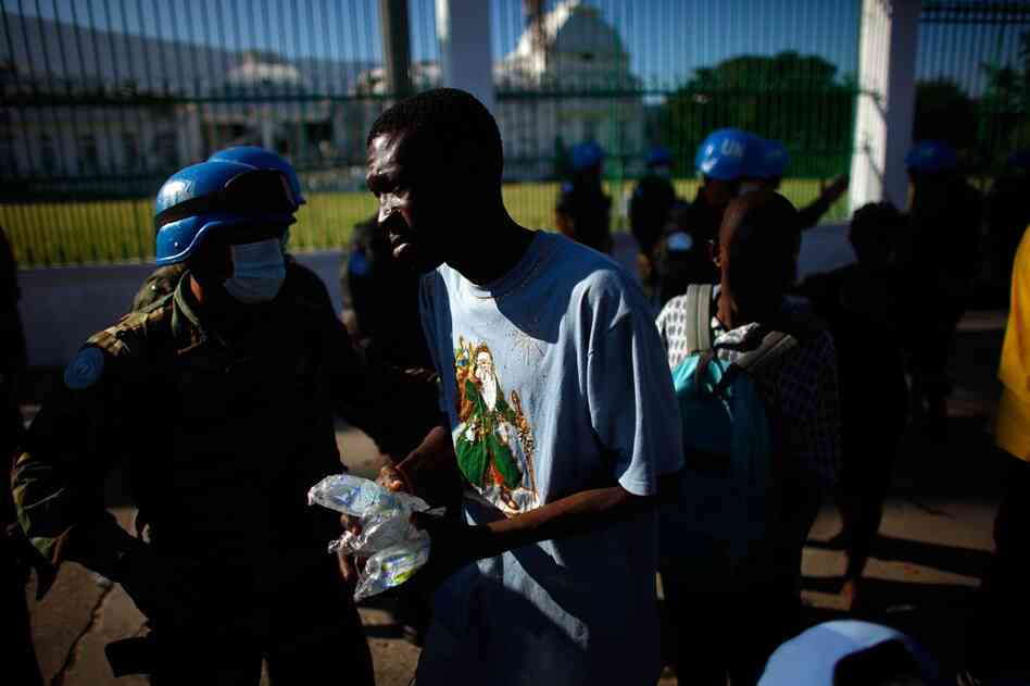 United Nations soldiers hand out water in front of the National Palace on Sunday.