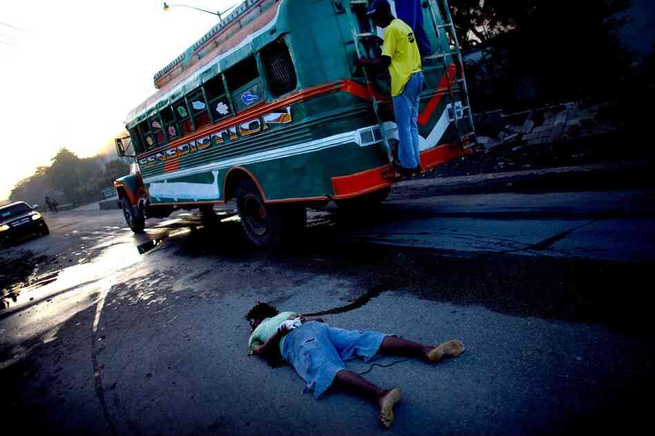 A body, with tied limbs and apparent gunshot wounds to the head, lies in the street Monday.