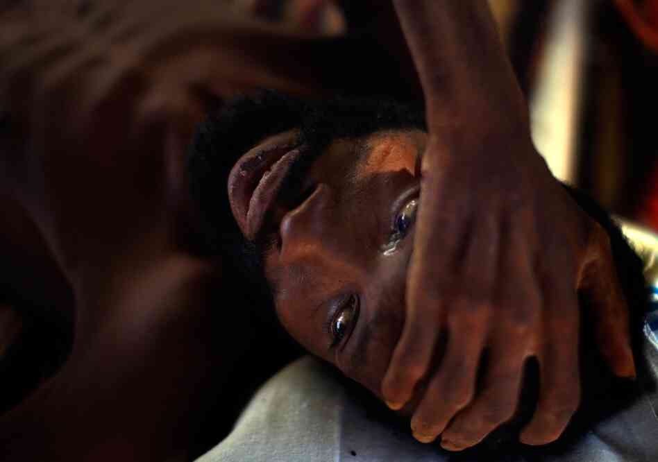Robenson Bernard cries at a hospital in downtown Port-au-Prince on Monday. Bedridden since November, none of the family members who used to take care of him have come since the quake.