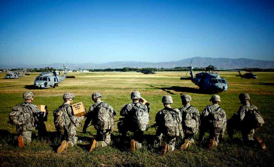 Soldiers with the U.S. Army's 82nd Airborne Division prepare to board helicopters to create operating bases across Port-au-Prince on Monday.