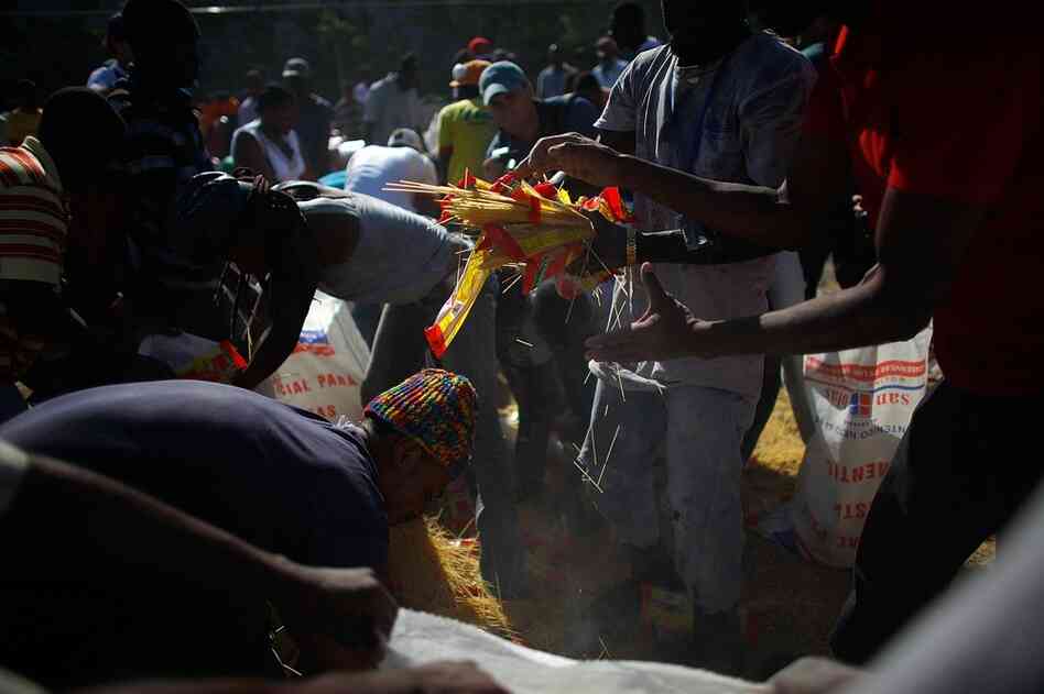 People scramble to pick up spilled spaghetti at the burning restaurant. With food supplies already low, the fire is yet another blow to a desperate capital.