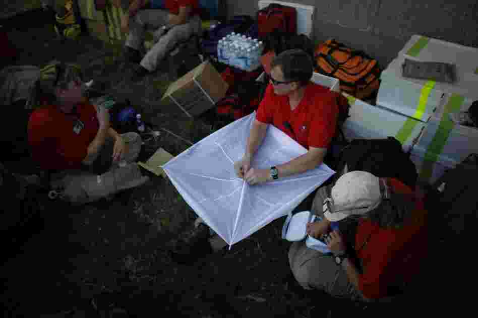 Disaster assistance teams from Georgia, California and Massachusetts hold a kite-making contest Sunday to pass the time and keep up morale. Days after leaving for Haiti, they still have not been able to get into the field to treat patients.