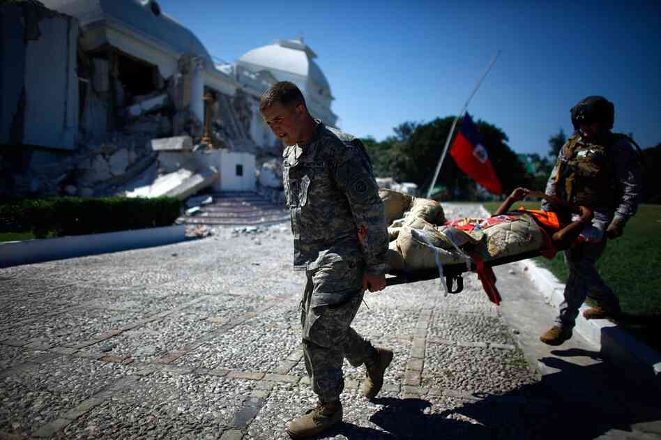 U.S. soldiers transfer patients to a staging area in front of the National Palace.