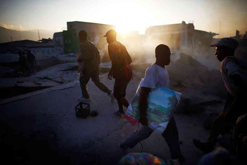 Men walk across the roof of a collapsed supermarket in Port-au-Prince Wednesday.