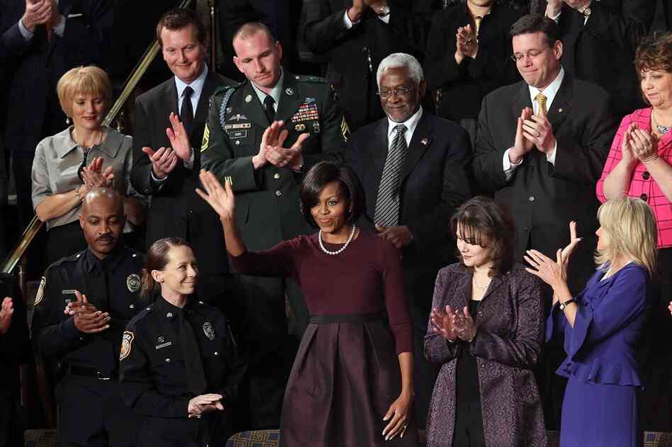 First lady Michelle Obama reacts to applause. At left: Officers Mark Todd and Kimberly Munley of Killeen, Texas. Directly above the first lady: Haitian Ambassador Raymond Joseph. At right: Rebecca Knerr and Jill Biden. 