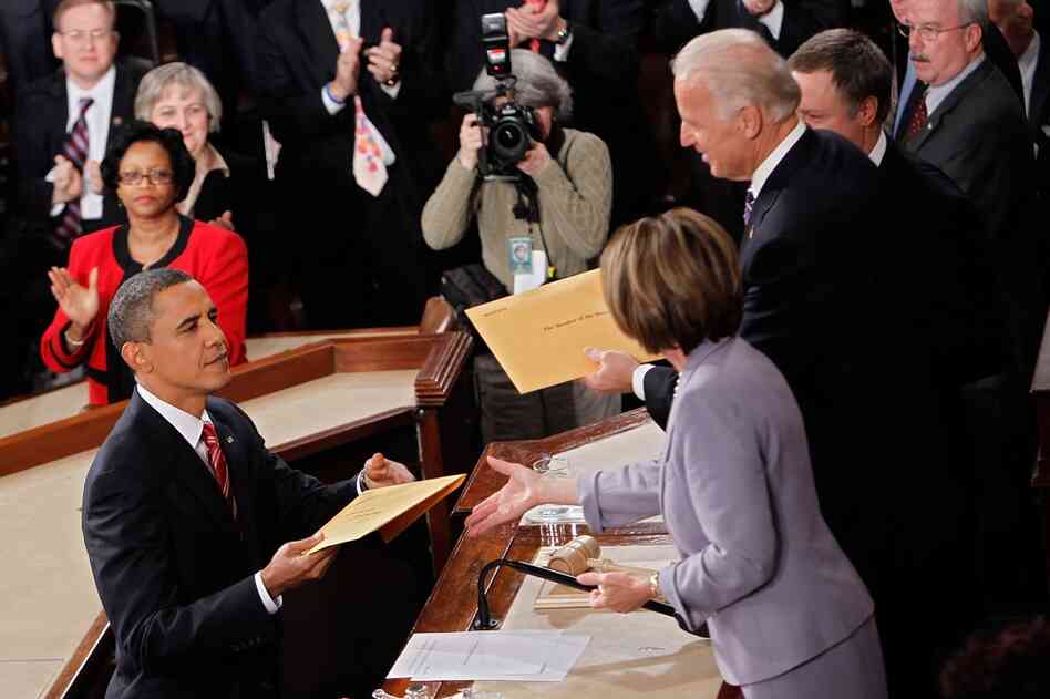 Obama hands copies of his speech to Biden and Speaker of the House Nancy Pelosi. 