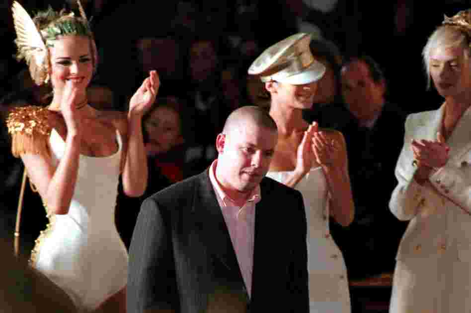 British fashion designer Alexander McQueen is surrounded by applauding models after a Paris show in 1997. The influential designer was found dead Thursday in his London home. He was 40 years old. 