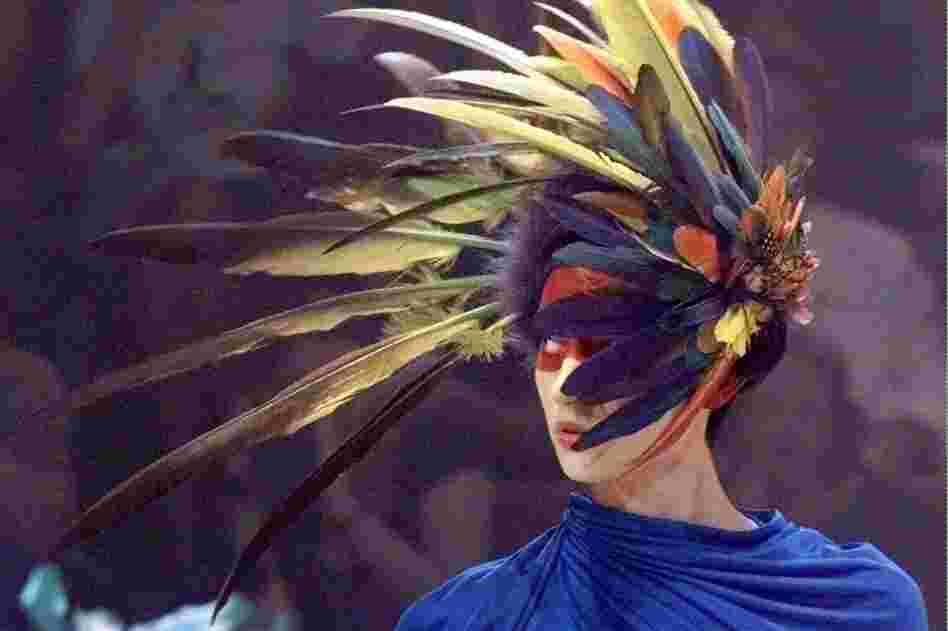 A model wears a feather headdress design by Alexander McQueen at a 1998 show in Paris. McQueen began his career at the age of 16 with an apprenticeship as a tailor on London's Savile Row. 