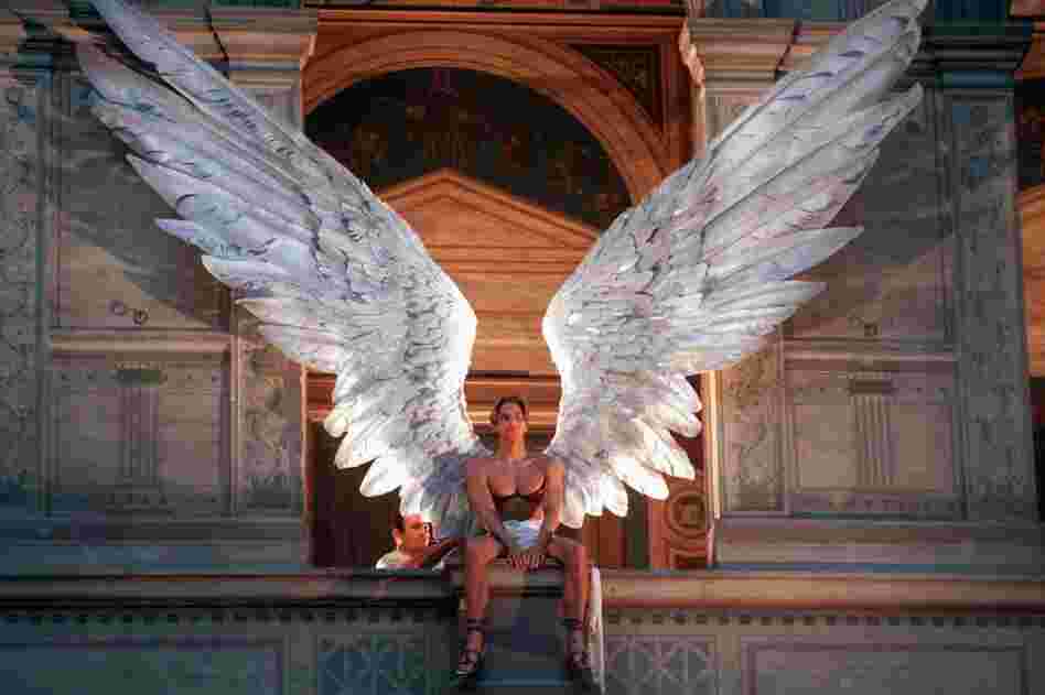 An employee adjusts the wings on a male model during Givenchy's 1997 spring/summer haute couture fashion collection by McQueen at a Paris show in January 1997. 