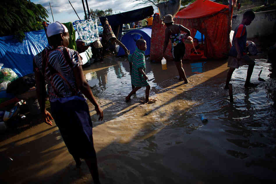 Families collect their belongings and begin moving out of their camp, flooded with waters containing sewage runoff. Aid organizations and government officials are scrambling to avoid a catastrophe when the rainy season intensifies.