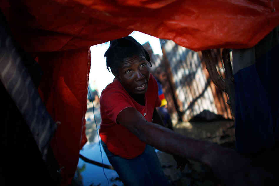 Margarette reaches out for help as she attempts to remove her belongings from her tent.