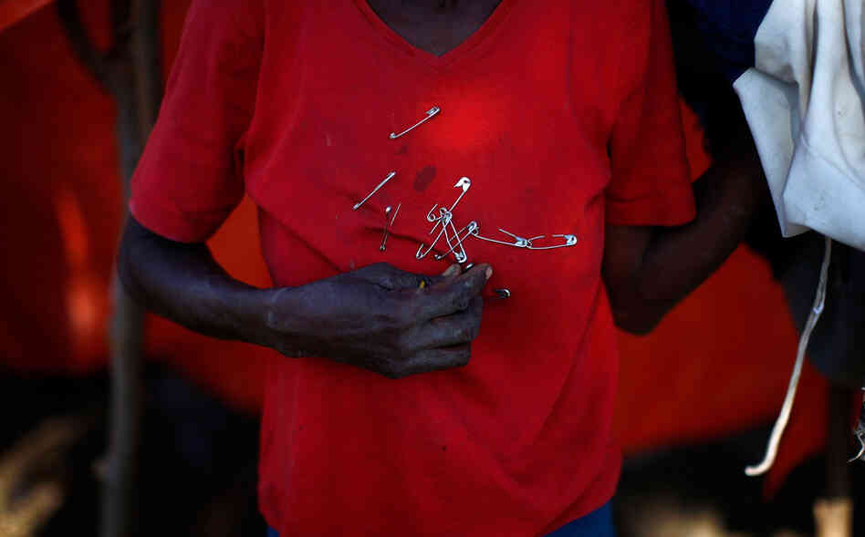 Margarette uses safety pins to hold up her makeshift roof. According to The Associated Press, approximately 1 million people are still homeless more than a month after the earthquake.