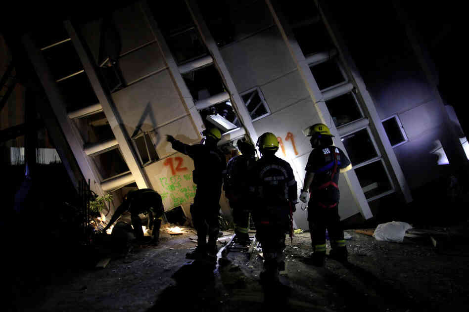 Firemen search for survivors in a destroyed building in Concepcion on Sunday. 
