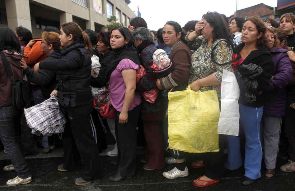 People wait for supplies in front of a supermarket in Concepcion. 