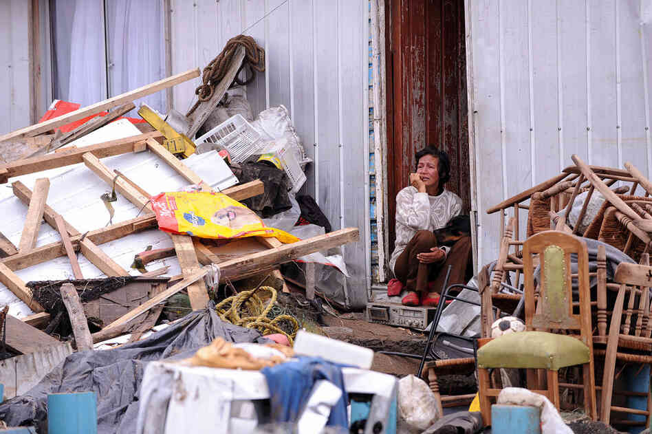 Bejamira Neira Zapata sits in the doorway of her house Monday after the massive earthquake struck the village of Penco. The tsunami engulfed the normally placid Penco and neighboring villages. 