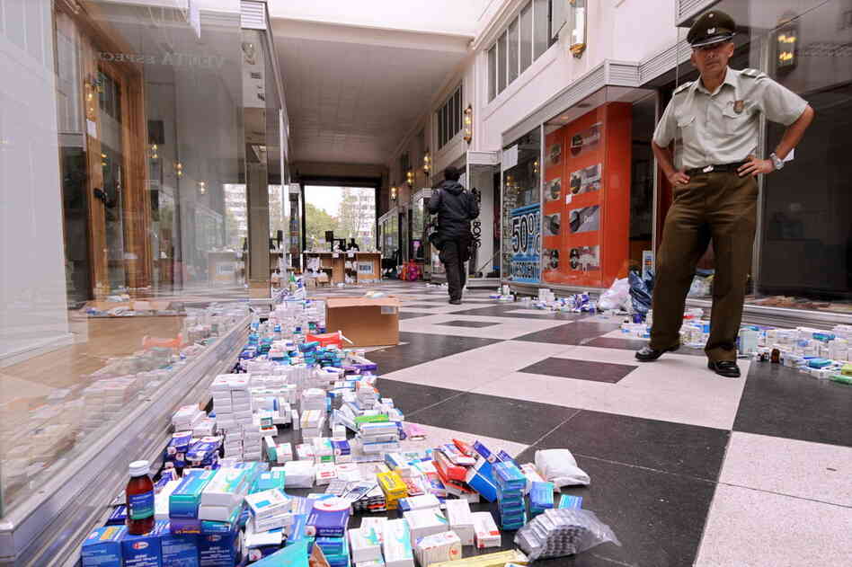 A policeman stands near medicine and other items donated Wednesday for earthquake victims. 