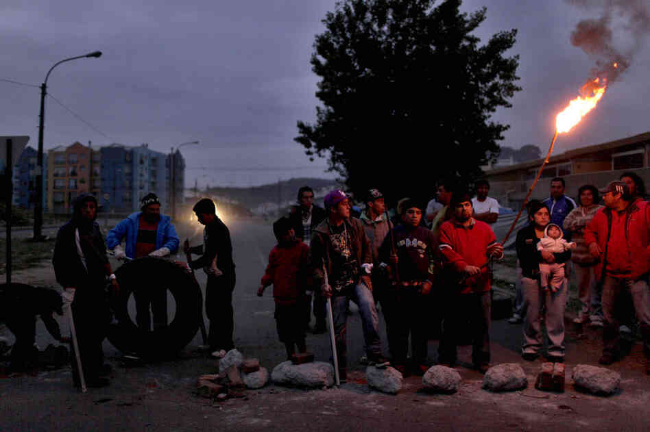 People in Concepcion stand outside guarding their homes on Monday. 
