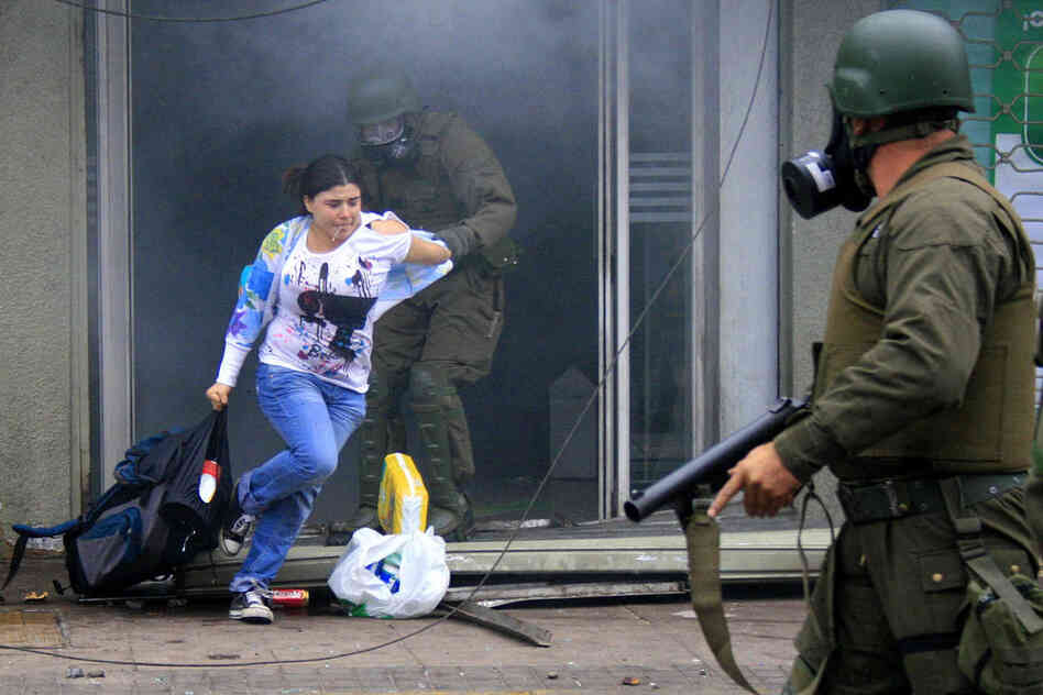 Police arrest a woman who was carrying goods out of a supermarket in Concepcion. 