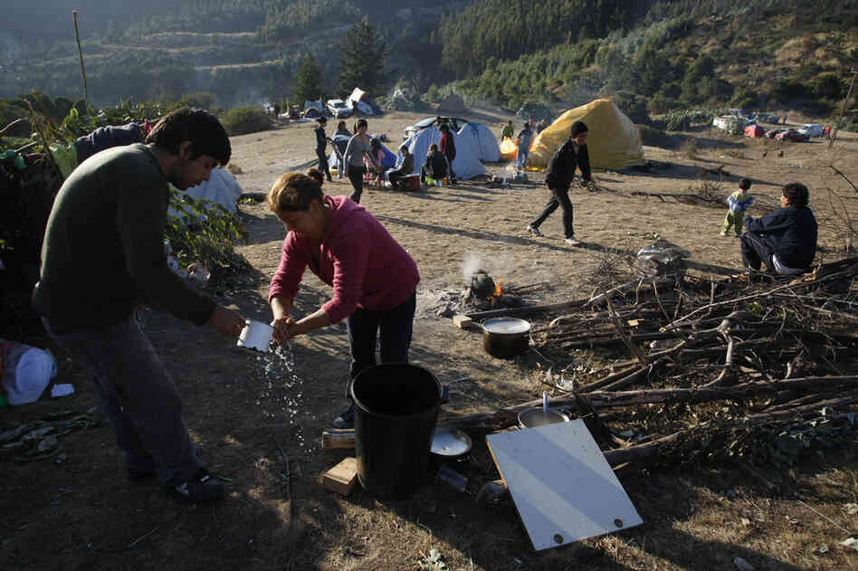 A woman washes her hands at a makeshift shelter for displaced people in the seaside town of Constitucion on Tuesday. 
