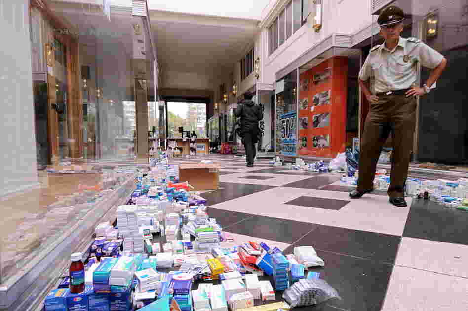 A policeman stands near medicine and other items donated Wednesday for earthquake victims. 