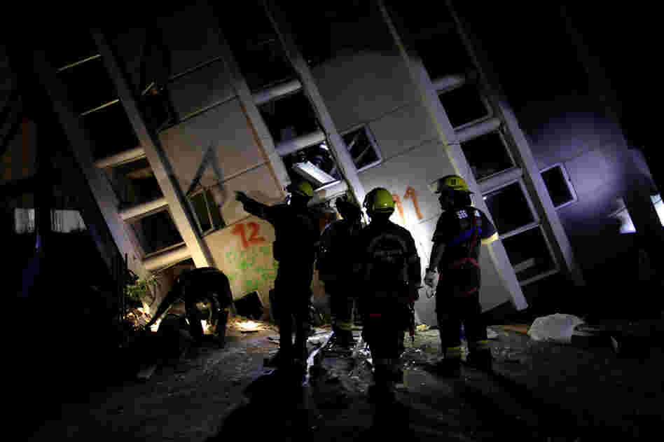 Firemen search for survivors in a destroyed building in Concepcion on Sunday. 