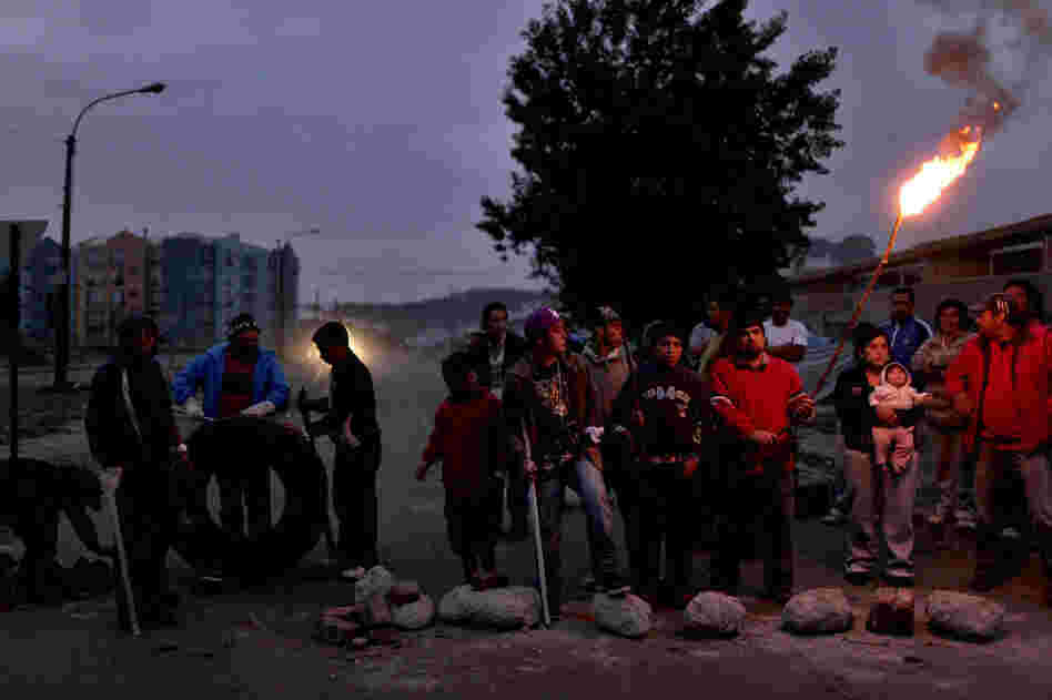 People in Concepcion stand outside guarding their homes on Monday. 