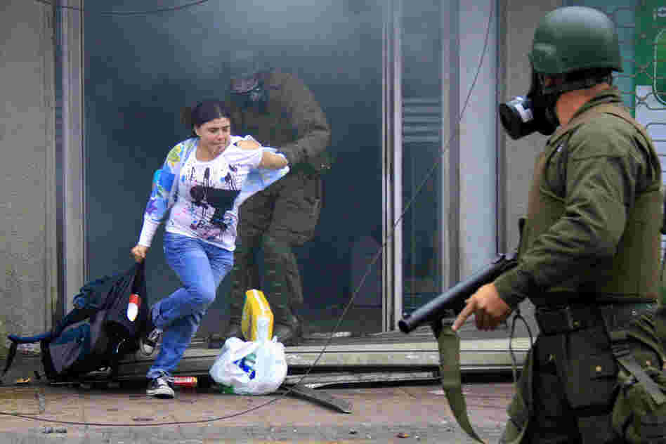 Police arrest a woman who was carrying goods out of a supermarket in Concepcion. 