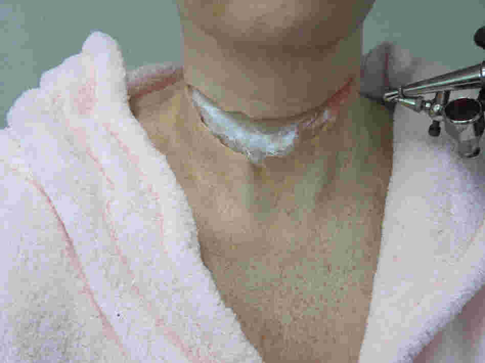 Cotton is placed into the slit of the latex, so that makeup artist Jerry Constantine can prepare the neck for what he calls "the meat" — the innards of the wound.