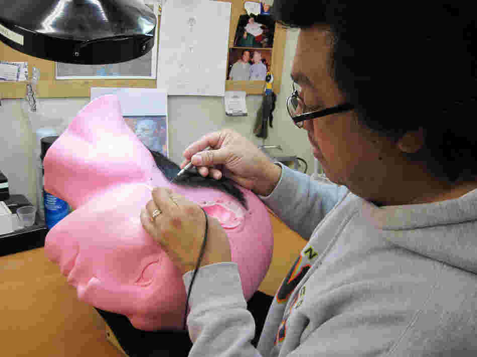 Michael Ornelaz, a wig maker at Legacy, fastens the hair to a superfine lace net — one strand at a time.