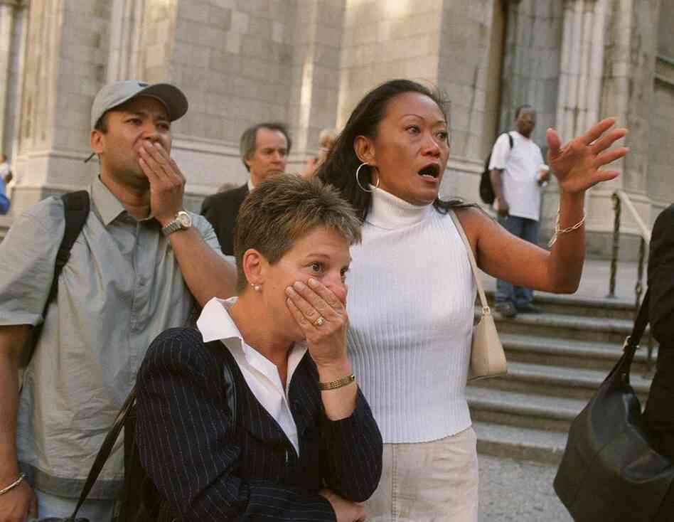 People in front of New York's St. Patrick's Cathedral react with horror as they see the World Trade Center towers after planes crashed into their upper floors.
