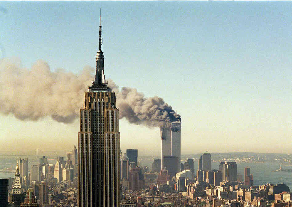 The twin towers of the World Trade Center burn behind the Empire State Building in New York, on Sept. 11, 2001.