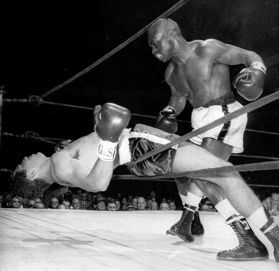 Rubin "Hurricane" Carter of Paterson, N.J., watches Florentino Fernandez of Cuba fall through the ropes after being knocked out in the first round of a fight at New York's Madison Square Garden.