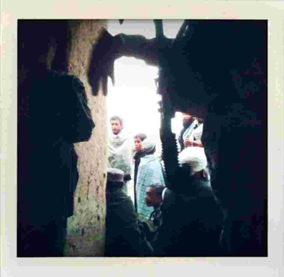 Afghan residents of Marjah gather around U.S. Marines as they patrol in Helmand province.
