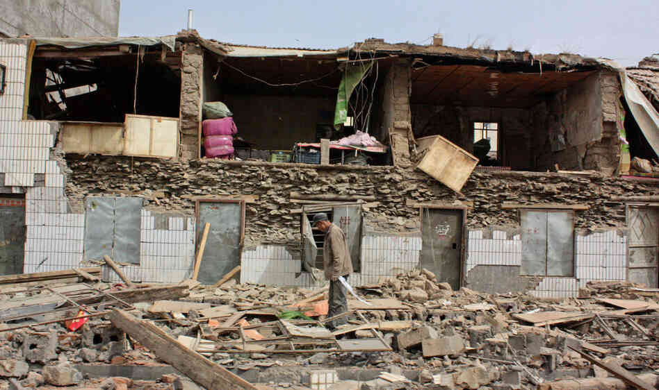 A man makes his way through the rubble in Jiegu Town after an earthquake early Wednesday April 14, 2010. 