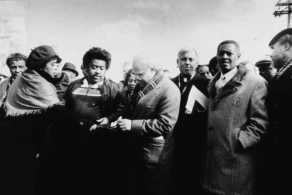 The Rev. Al Sharpton (second from left) and Hooks (center) accept candles from future New York Supreme Court Justice Laura Blackburne at a memorial commemorating a racially motivated attack in Queens, N.Y., on Dec. 27, 1987. 