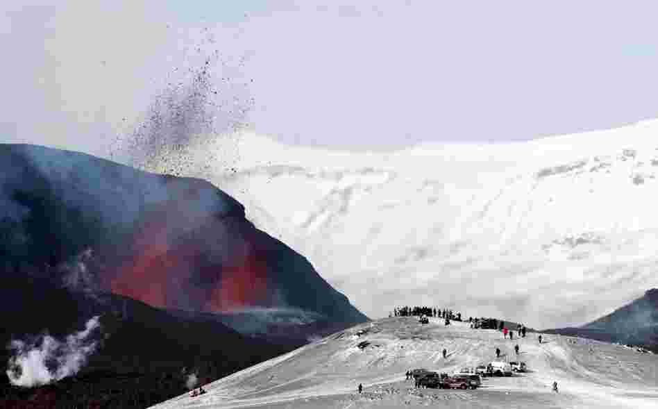 Tourists gather to watch lava spurt out of the Fimmvorduhals volcano, near the Eyjafjallajokull glacier. 