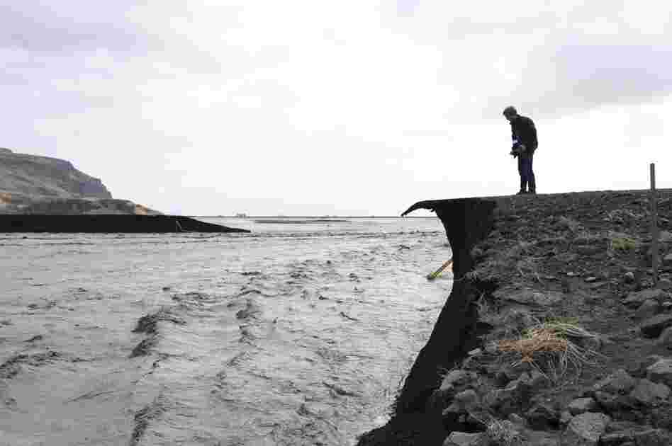A man takes a picture of a road that has been washed away by floodwaters from the melting Eyjafjallajokull glacier, caused by the April 14 eruption. 