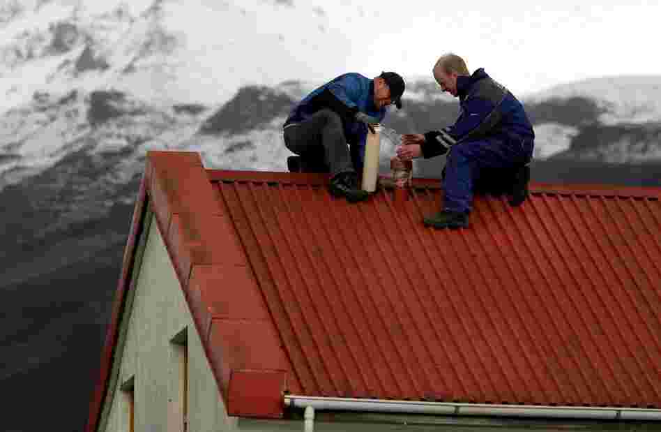 Men near Myrdalssandur, Iceland, wrap a house vent in plastic film on April 16 to prevent the entry of airborne volcanic ash. Winds pushed the ash plume south and east across Britain, Ireland, and Scandinavia into the heart of Europe. 