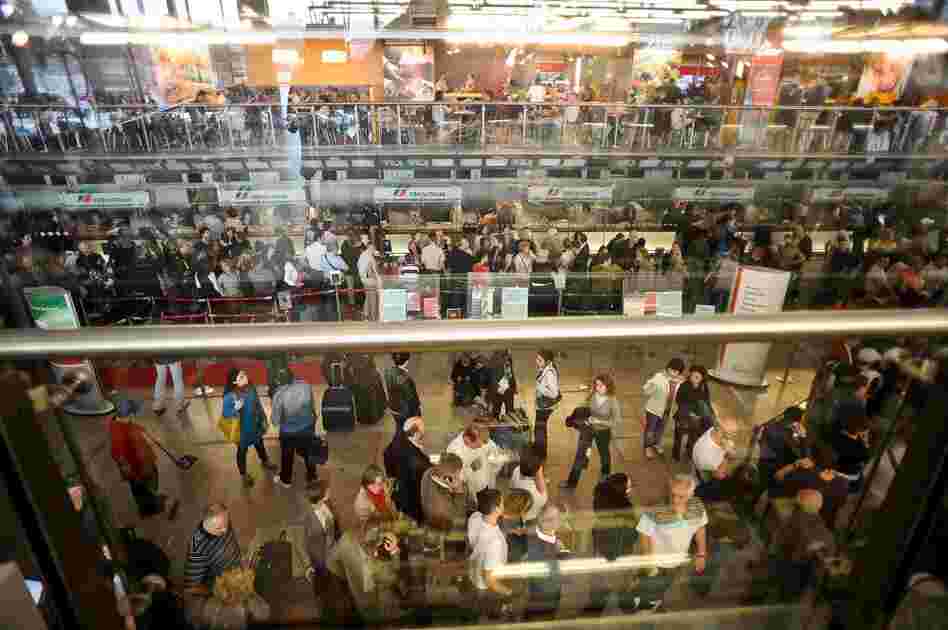 Passengers wait to buy tickets at Termini central train station in Rome on April 18. Stranded airline travelers are turning to alternative transportation in attempts to get home. 
