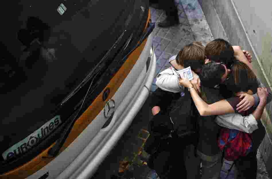 A family from Reading, England, embraces after getting bus tickets to France at the bus station in Barcelona, Spain, on April 19. The family had been stranded in Barcelona since April 15. 