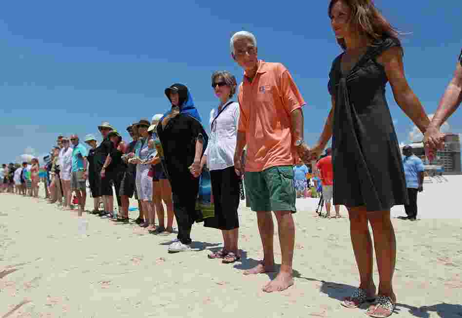 Florida Gov. Charlie Crist and wife Carole Rome Crist (right) stand with others during a Hands Across the Sand event June 26 in Pensacola, Fla. The event was staged across the nation to protest offshore oil drilling. 