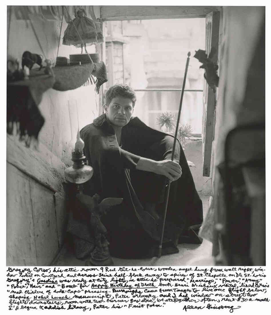 "Gregory Corso, his attic room 9 Rue Git-le-Coeur, wooden angel hung from wall right, window looked on courtyard and across Seine half-block away to spires of St. Chapelle on Ile St. Louis." 1956