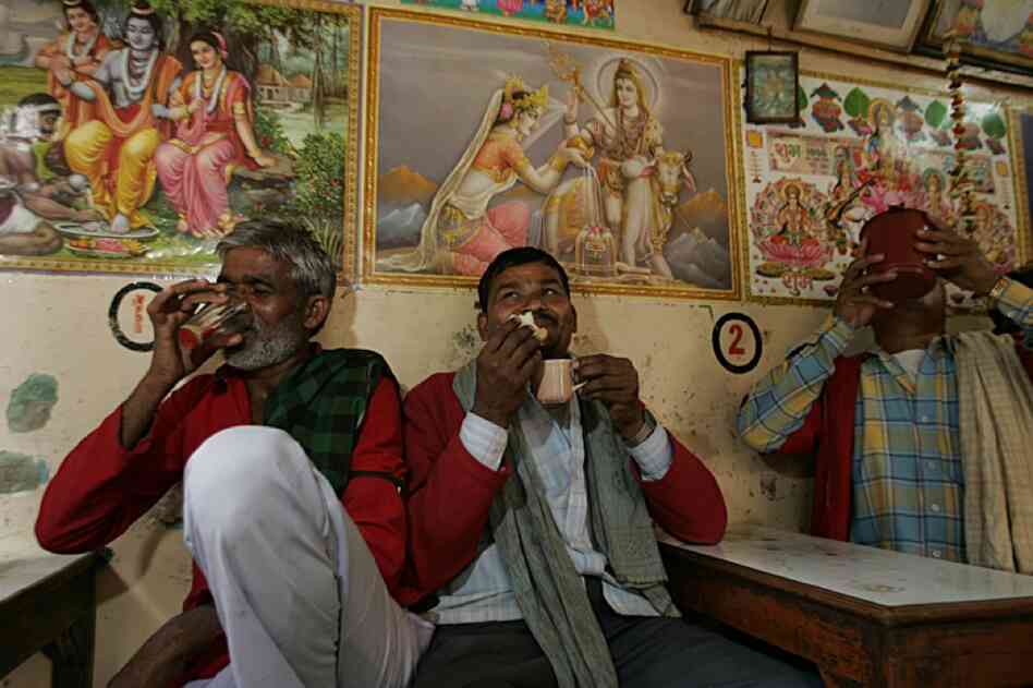 Railroad bellmen take a chai break at a tea stand in the food market in the Pahargangh neighborhood in Delhi, India, February 2007.