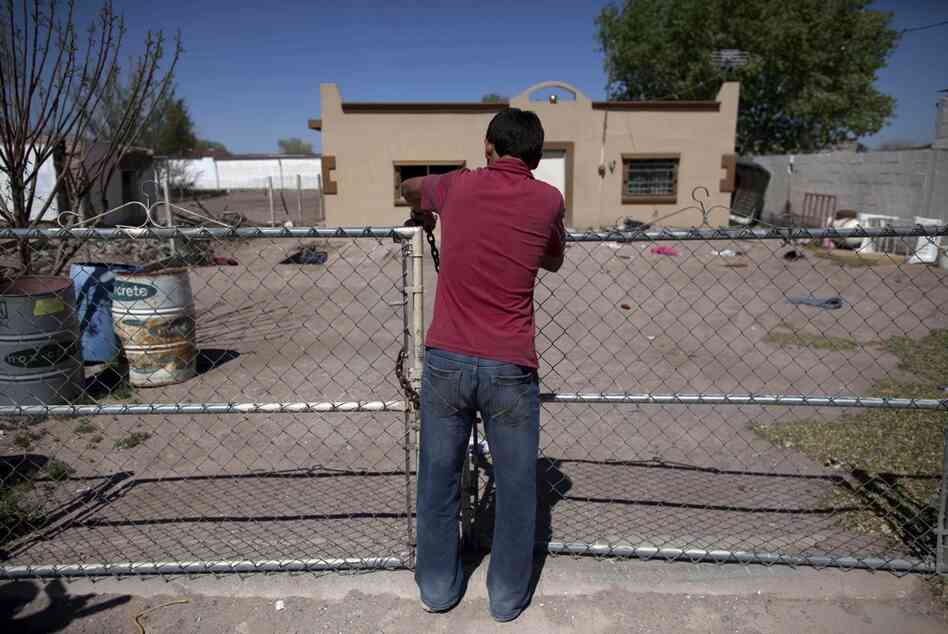 A 14-year-old boy locks the front gate of his house while fleeing El Porvenir with his family.