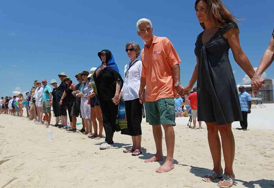 Florida Gov. Charlie Crist and wife Carole Rome Crist (right) stand with others during a Hands Across the Sand event June 26 in Pensacola, Fla. The event was staged across the nation to protest offshore oil drilling. 