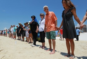 Florida Gov. Charlie Crist and wife Carole Rome Crist (right) stand with others during a Hands Across the Sand event June 26 in Pensacola, Fla. The event was staged across the nation to protest offshore oil drilling.