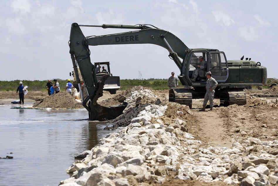 Members of the Louisiana National Guard build a land bridge at the mouth of wetlands on Elmer's Island. 