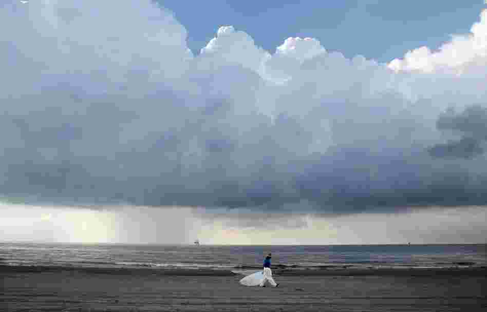A worker leaves the beach in Grand Isle, La., on May 30. BP is turning to yet another mix of undersea robot maneuvers to help keep more crude oil from flowing into the Gulf. 